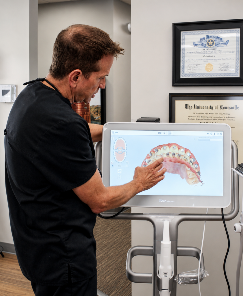 An orthodontist looks at a scan of a mouth on a computer screen for Invisalign treatment
