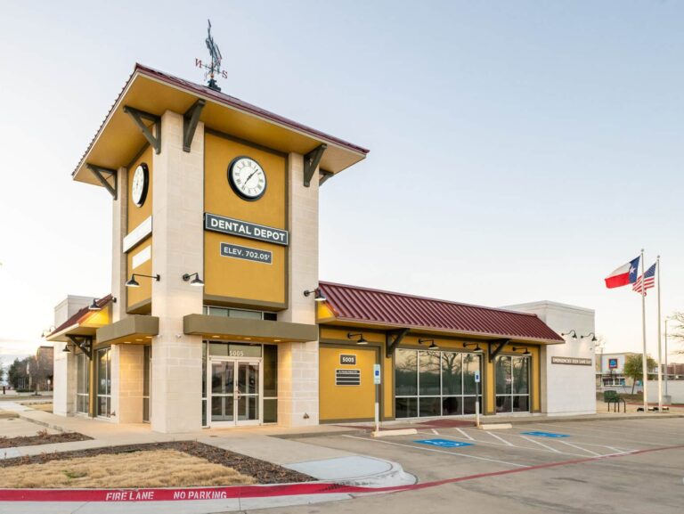 Exterior view of Dental Depot's Arlington dentist office with yellow walls, a clock tower, and red roof.