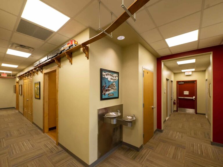 View of the office hallways with a model train running on a track toward the top of the walls.