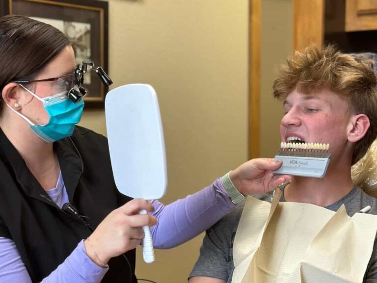 A young man has his teeth color compared to a chart