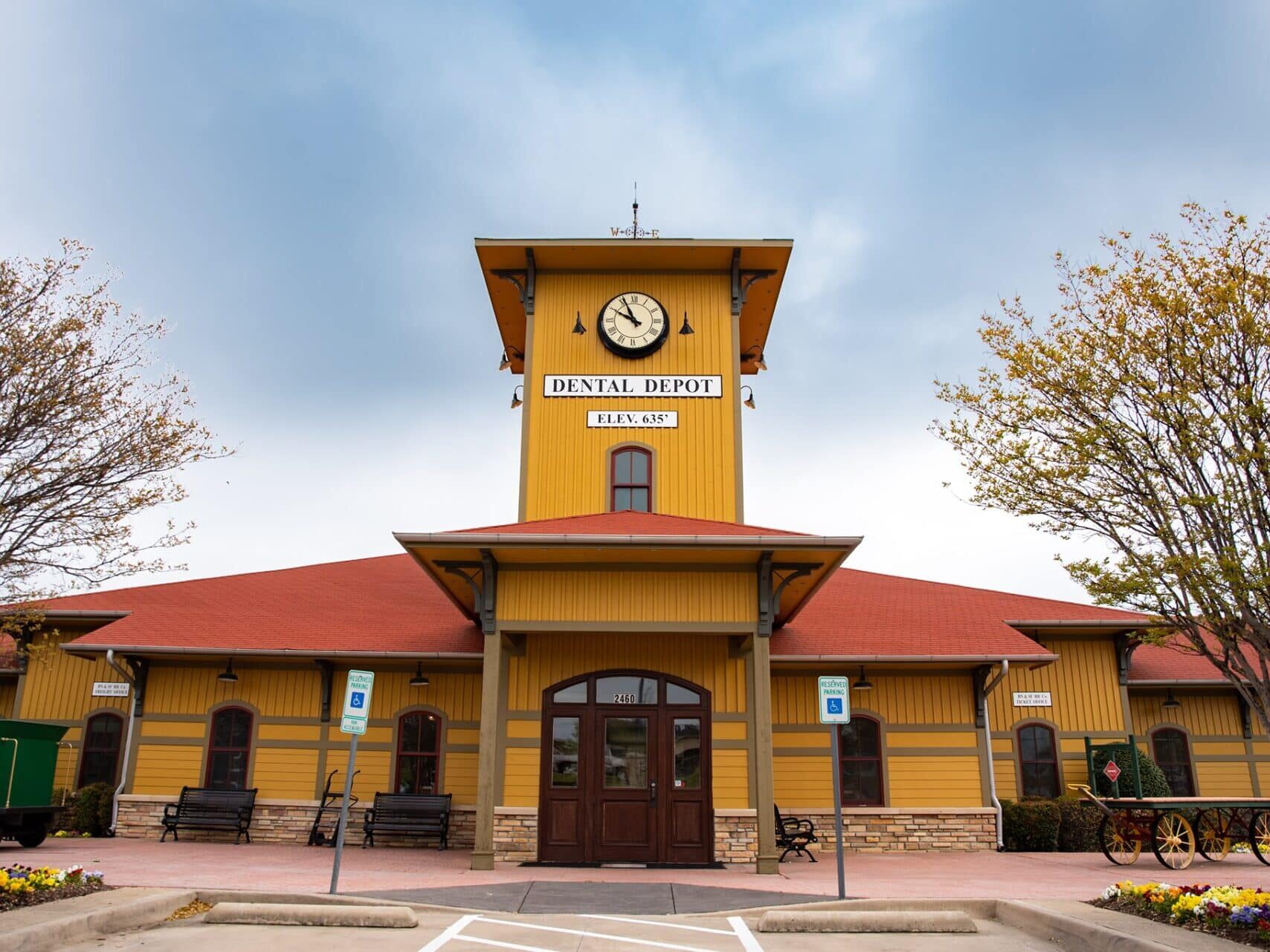 Dental Depot's Highland Village dentist office with a red roof, yellow walls, and a clock tower.
