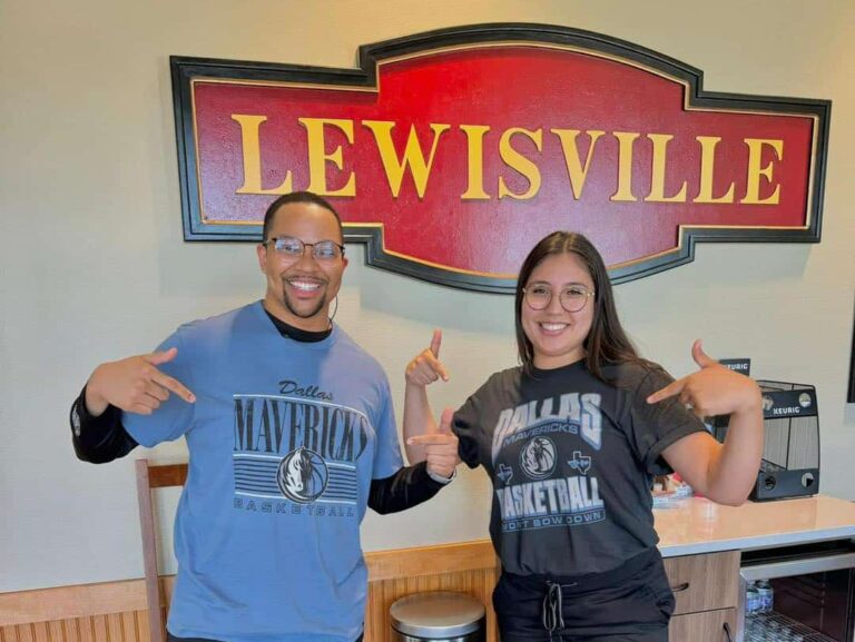 Dental providers at Dental Depot pose in their Mavs shirts in front of the Lewisville sign