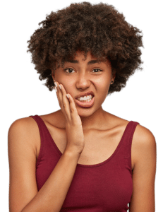 woman holding her cheek due to tooth ache