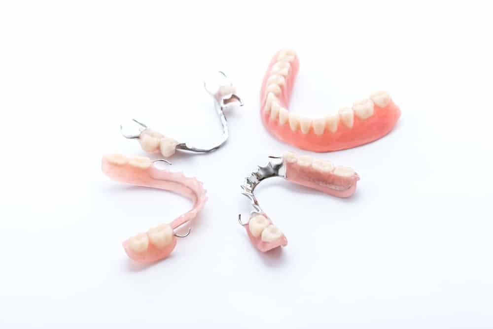 Sets of full and partial dentures arranged on a white background